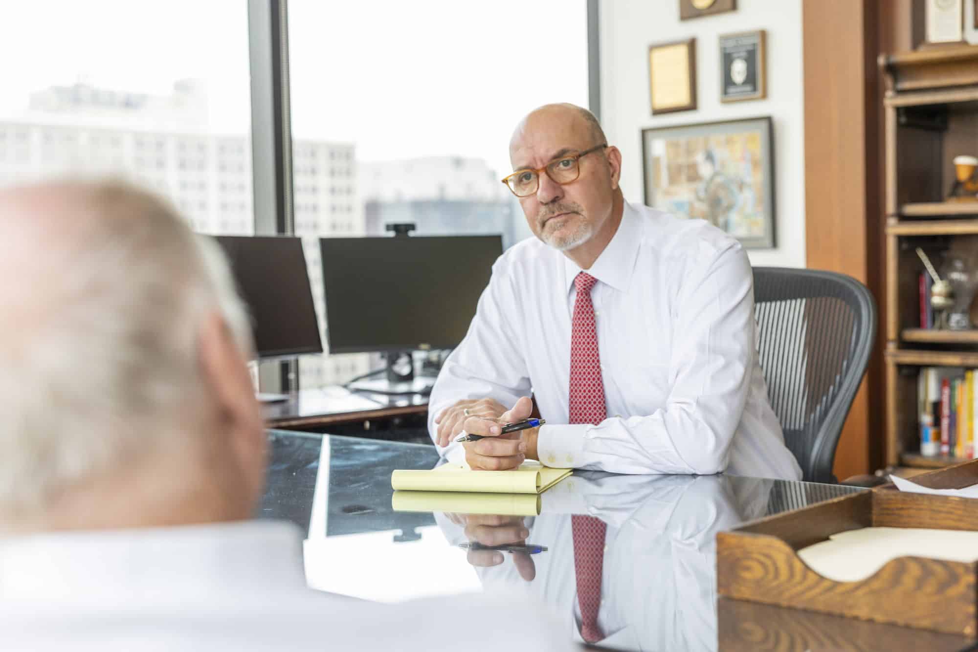 Attorney Gonzalo sitting with a client and consulting with him about his case.